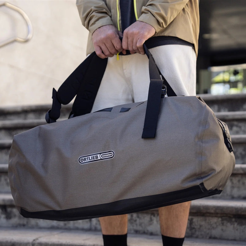 Lade das Bild in Galerie -Viewer, Ortlieb Duffle Lite Reisetasche getragen
